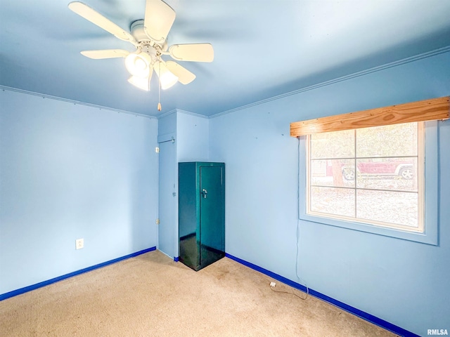 unfurnished bedroom with ceiling fan, light colored carpet, and crown molding