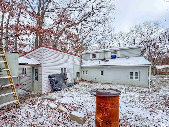 snow covered house featuring an outdoor fire pit