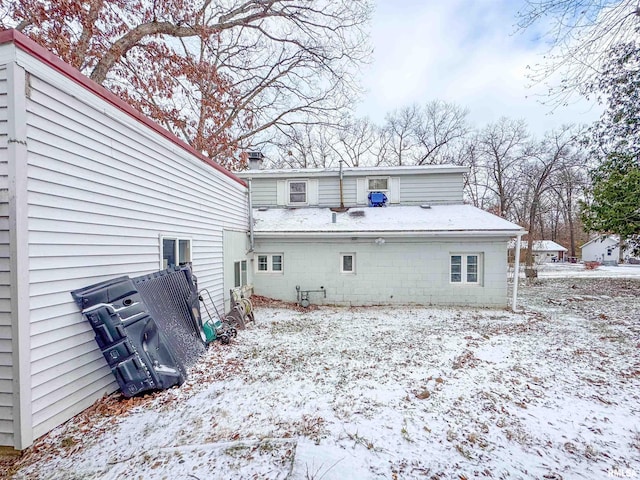 view of snow covered back of property