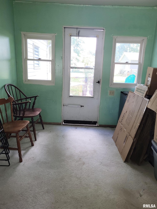 doorway featuring a healthy amount of sunlight and light colored carpet