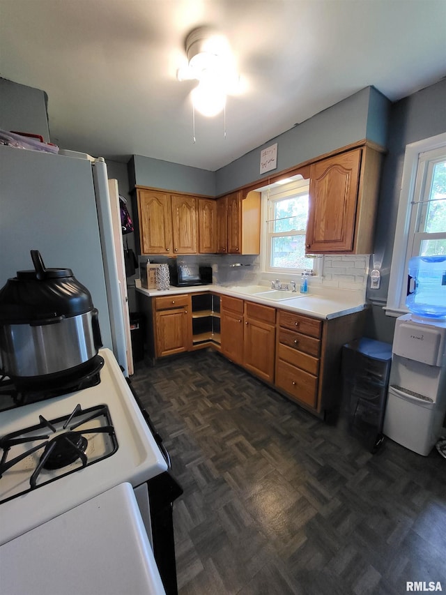 kitchen with white appliances, dark parquet floors, tasteful backsplash, and sink