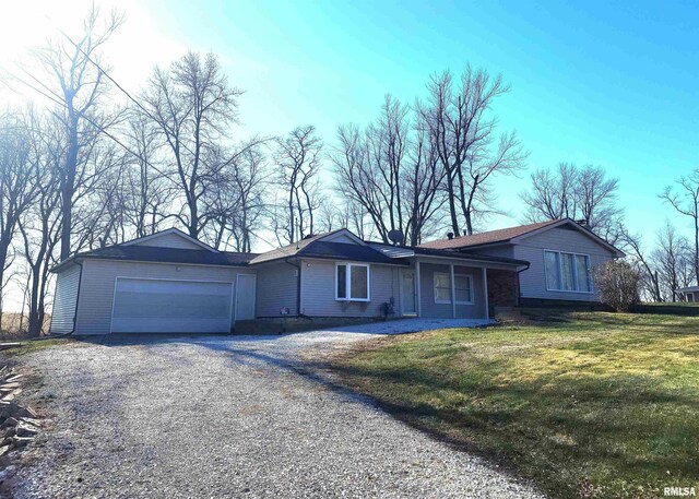 ranch-style home featuring a garage and a front lawn