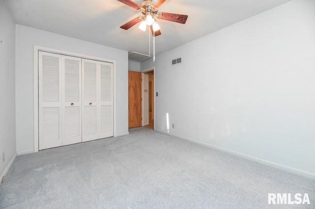 unfurnished bedroom with ceiling fan, light colored carpet, and a closet