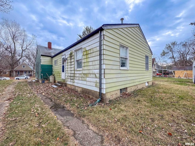 view of side of home with a lawn