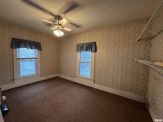 unfurnished room with ceiling fan, carpet floors, and a textured ceiling