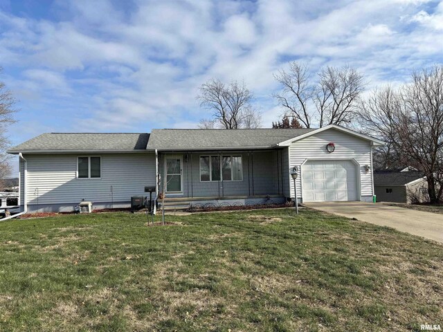 ranch-style house featuring covered porch, a front yard, and a garage