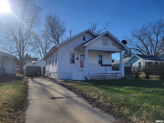 bungalow featuring covered porch and a front lawn