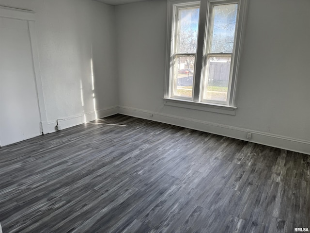 spare room featuring plenty of natural light and dark hardwood / wood-style floors