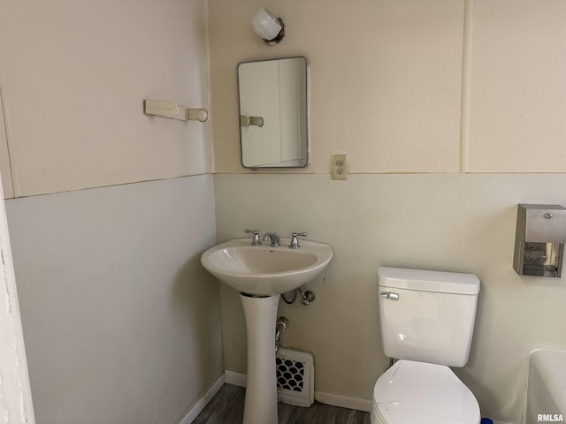 bathroom featuring toilet and wood-type flooring