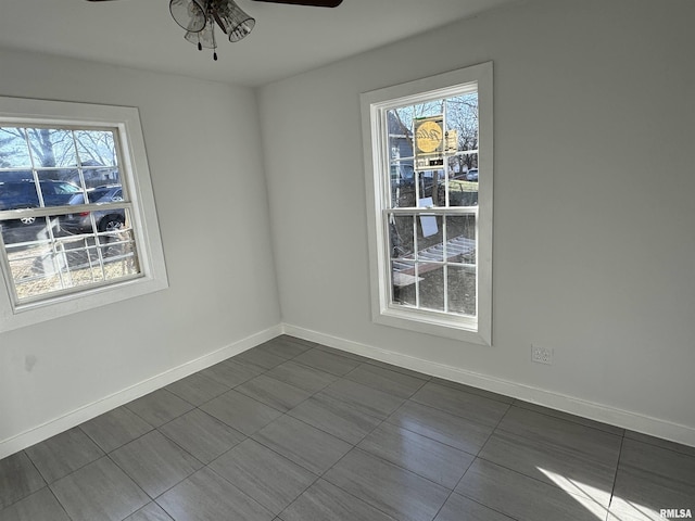 tiled spare room featuring ceiling fan