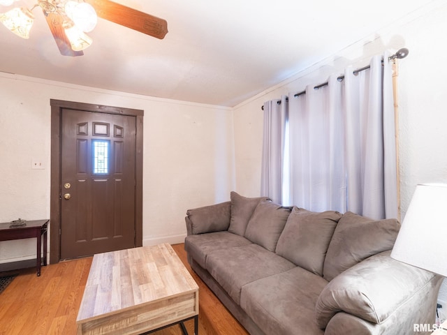 living room featuring light hardwood / wood-style floors, ceiling fan, and crown molding