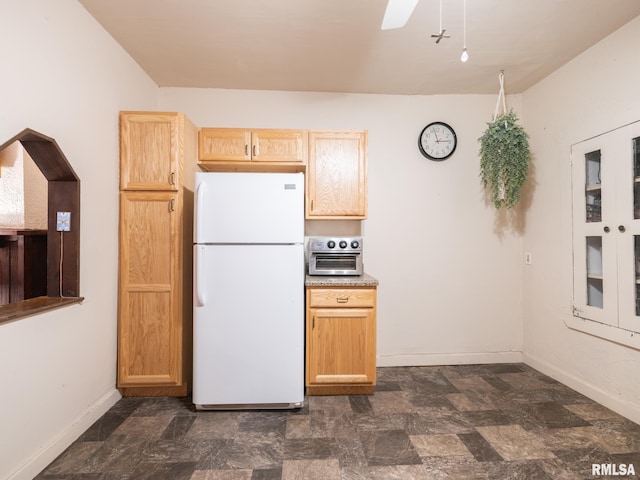 kitchen featuring ceiling fan, light brown cabinets, and white fridge