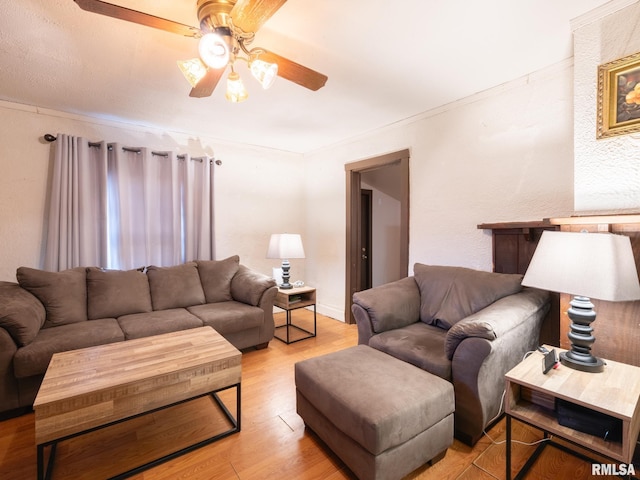 living room featuring ceiling fan, light hardwood / wood-style floors, and ornamental molding