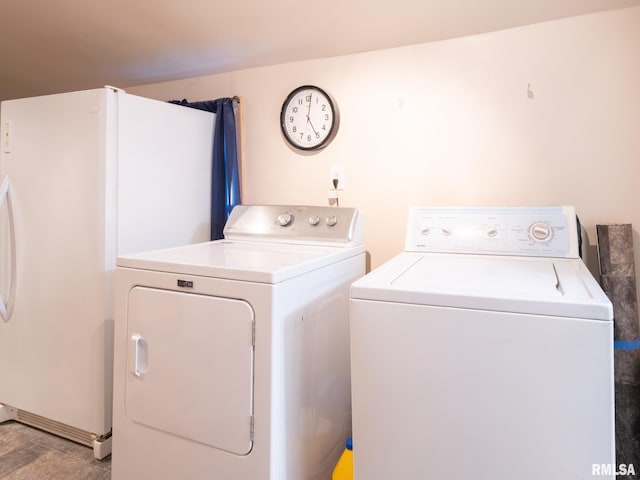 laundry area featuring washer and clothes dryer and light hardwood / wood-style floors