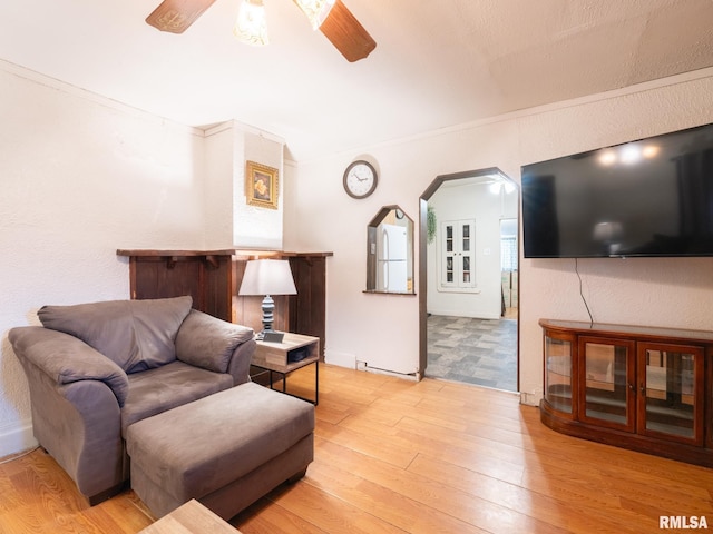 living room featuring light wood-type flooring and crown molding