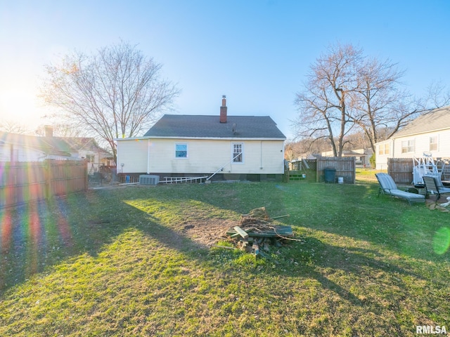 back of house featuring central AC and a yard