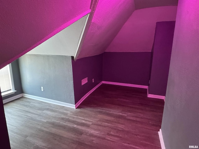 additional living space featuring dark hardwood / wood-style flooring and vaulted ceiling