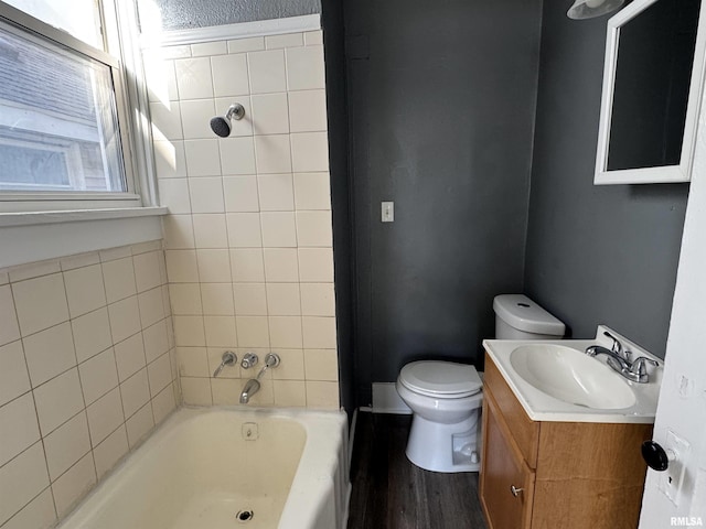 bathroom featuring hardwood / wood-style floors, a washtub, toilet, and vanity