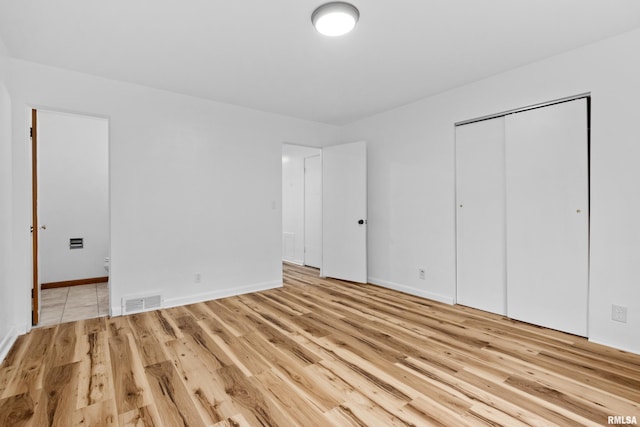 unfurnished bedroom featuring a closet and light wood-type flooring