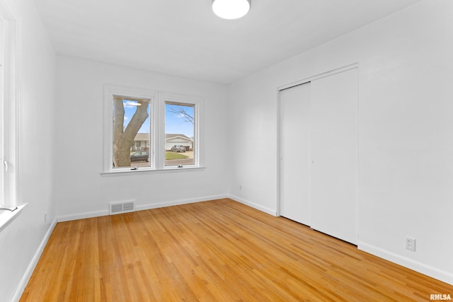 unfurnished bedroom with wood-type flooring and a closet