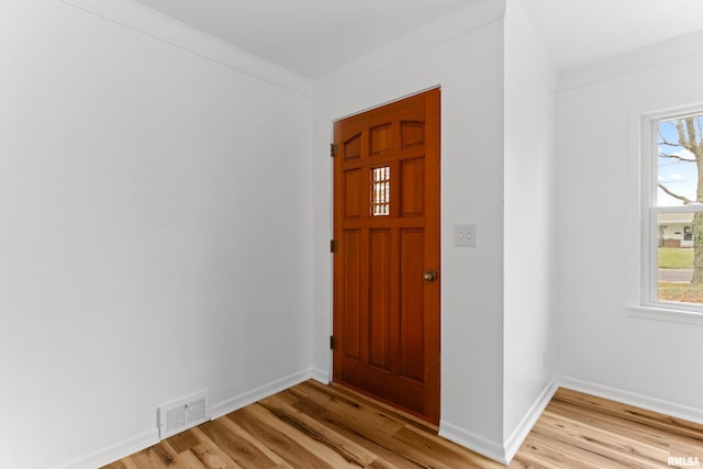 entryway with crown molding and light hardwood / wood-style flooring