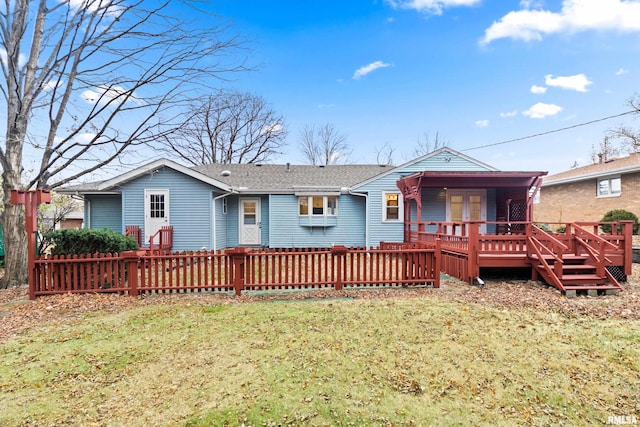 back of property featuring a lawn and a deck