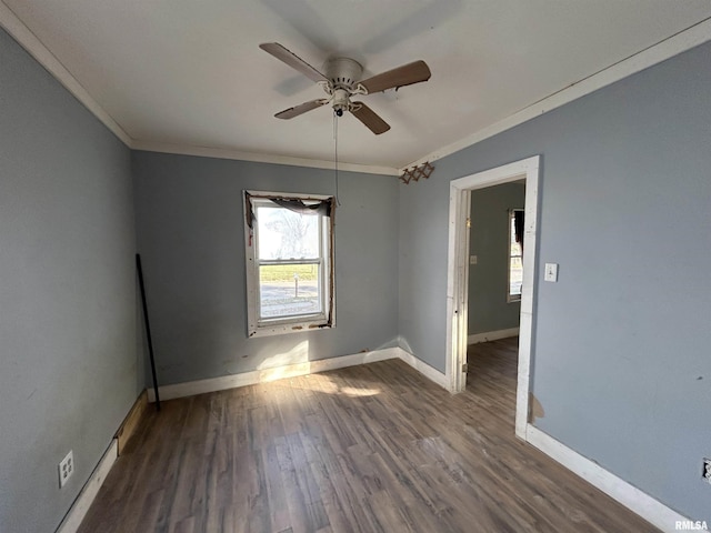 empty room featuring ceiling fan, dark wood-type flooring, and ornamental molding