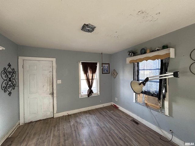 interior space with dark hardwood / wood-style floors and a healthy amount of sunlight