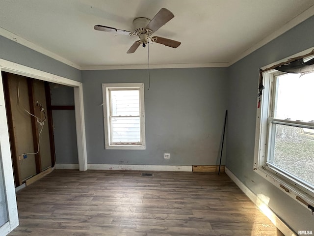 unfurnished bedroom featuring ceiling fan, ornamental molding, and dark wood-type flooring