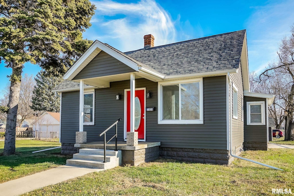 bungalow-style house featuring a front lawn