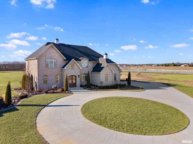 french provincial home featuring a front yard and french doors