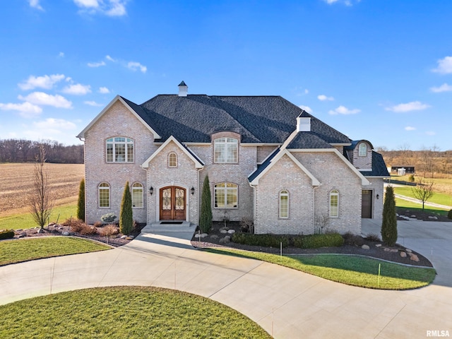 1980 Nofsinger Rd, Washington, IL 61571 - french country inspired facade featuring french doors, curved driveway, a chimney, brick siding, and a front lawn