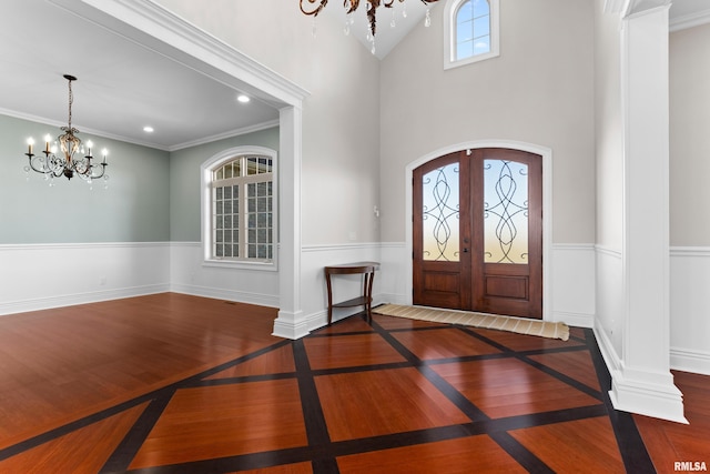 entryway featuring an inviting chandelier, arched walkways, wood finished floors, and french doors