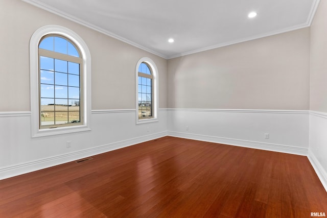 spare room featuring dark wood-style flooring, recessed lighting, visible vents, ornamental molding, and baseboards