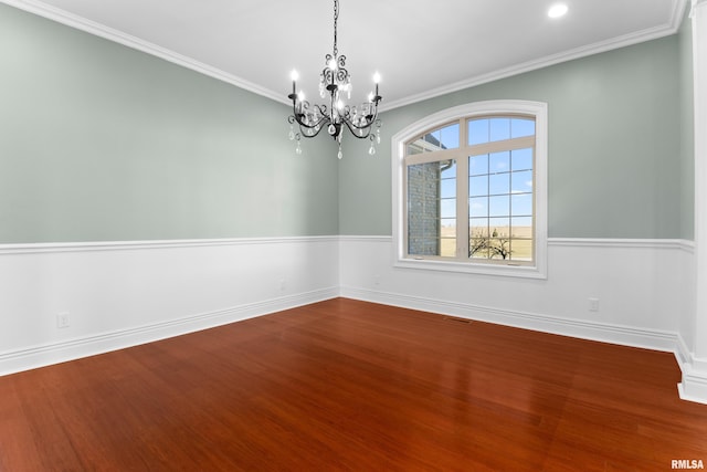 spare room with baseboards, ornamental molding, and wood finished floors