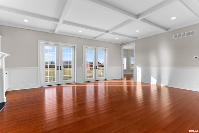 unfurnished living room with hardwood / wood-style floors, french doors, wainscoting, and visible vents