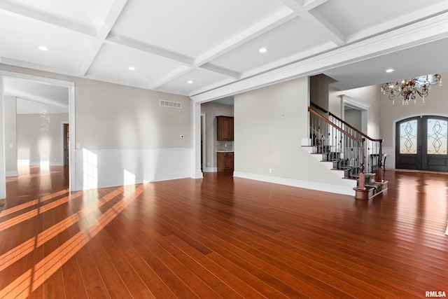 unfurnished living room with coffered ceiling, visible vents, french doors, stairway, and wood-type flooring