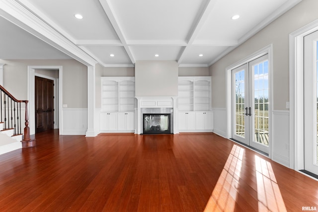 unfurnished living room featuring a premium fireplace, coffered ceiling, wood finished floors, french doors, and beam ceiling