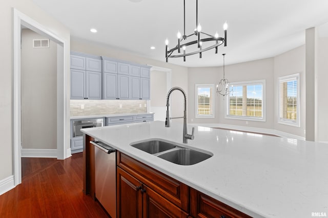 kitchen with visible vents, dark wood-style floors, appliances with stainless steel finishes, a sink, and backsplash