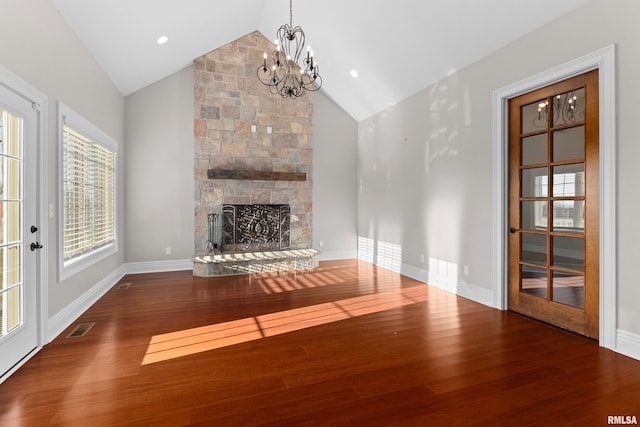 unfurnished living room featuring baseboards, visible vents, a fireplace, and hardwood / wood-style floors