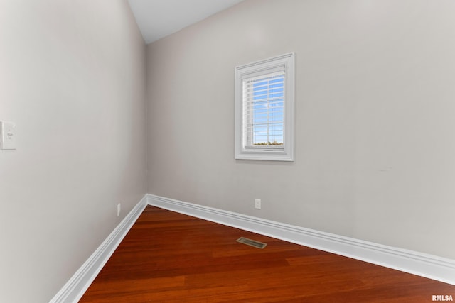 spare room featuring visible vents, baseboards, and wood finished floors