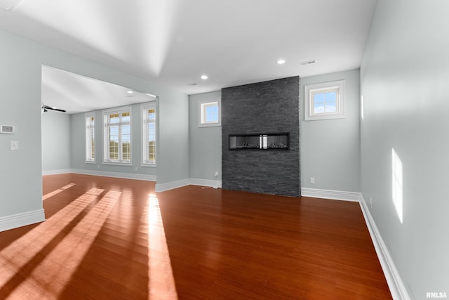 unfurnished living room with a fireplace, baseboards, wood finished floors, and recessed lighting