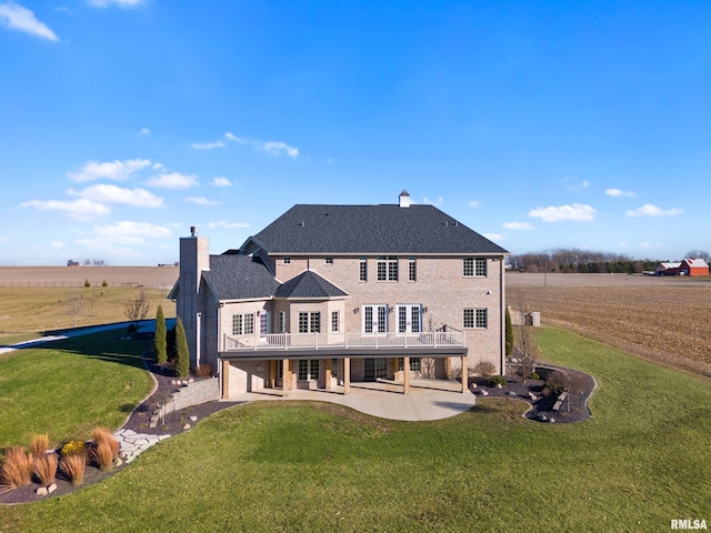 rear view of house featuring a deck, a patio, a yard, and a chimney