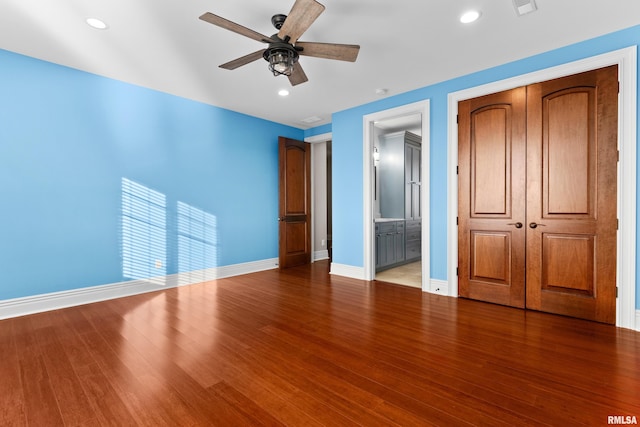 unfurnished bedroom with a closet, baseboards, and wood finished floors