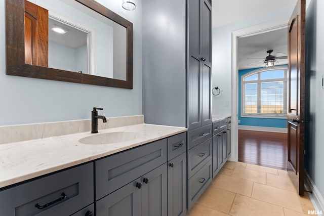 bathroom featuring baseboards, tile patterned flooring, vanity, and a ceiling fan