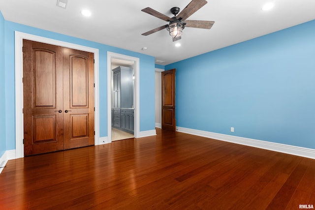 unfurnished bedroom with a closet, recessed lighting, wood finished floors, and baseboards