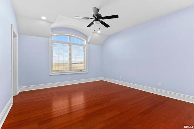 empty room with lofted ceiling, recessed lighting, wood finished floors, a ceiling fan, and baseboards