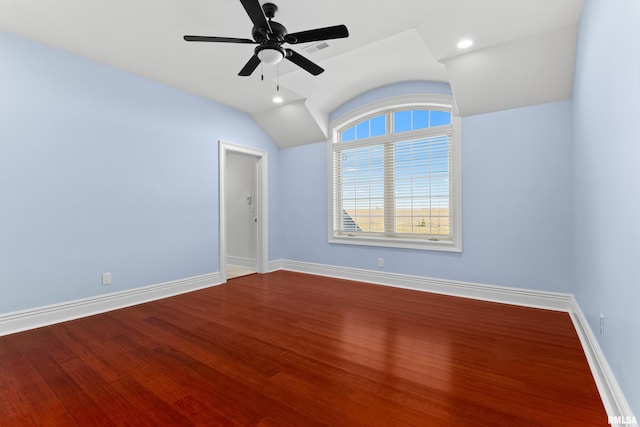 empty room with baseboards, vaulted ceiling, wood finished floors, and recessed lighting