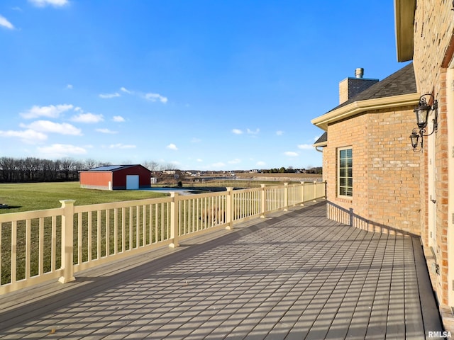 deck featuring an outbuilding, a yard, and a detached garage