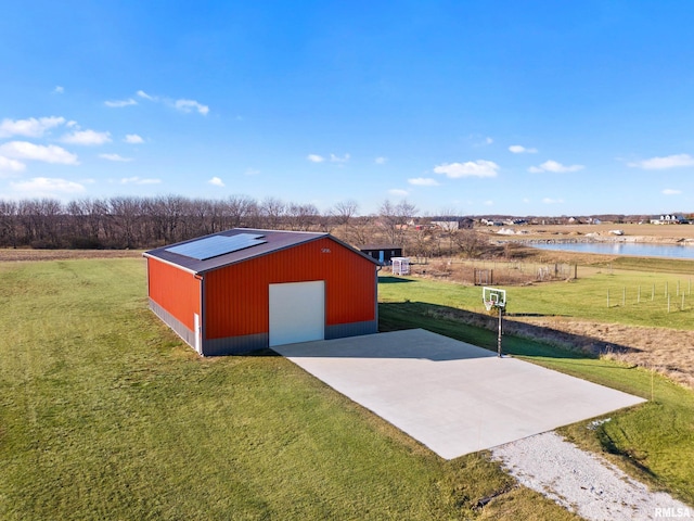 view of pole building with a yard and a water view